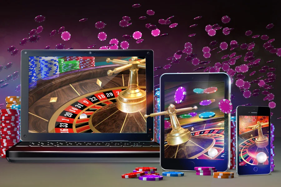 a laptop and tablet with roulette wheel and chips flying